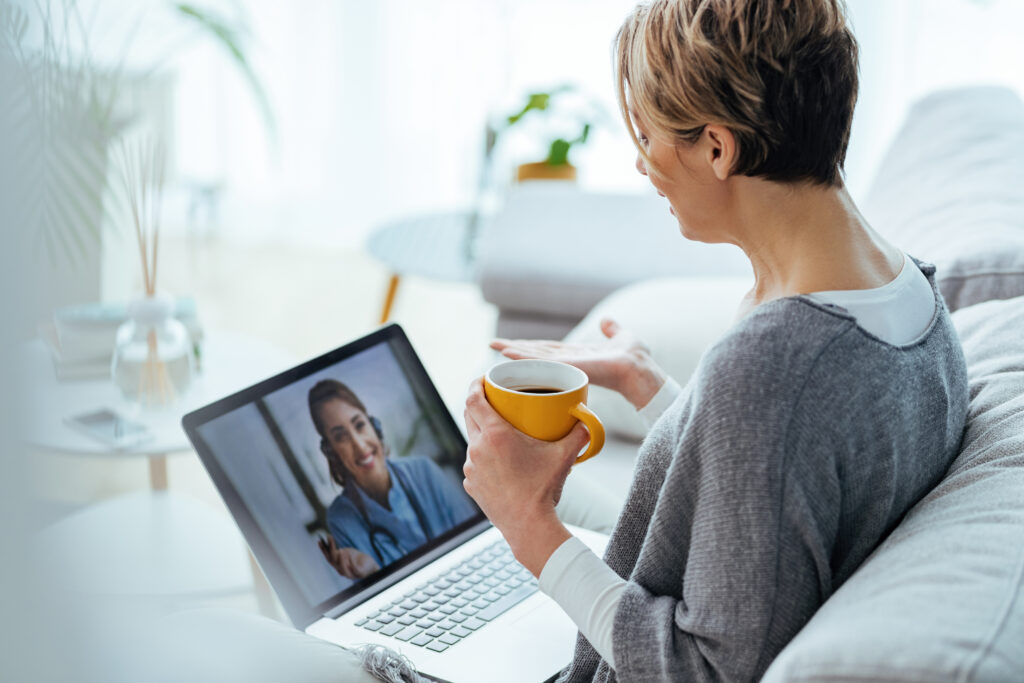 woman using laptop and having video call with her doctor while s